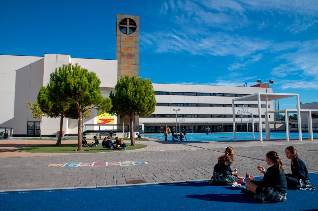 a group of people sitting on a blue surface in front of a building