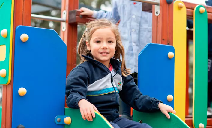 Niña jugando en un parque infantil.